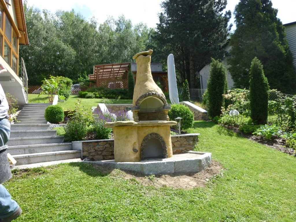 Gemauerter Grillkamin mit Holzdach in einem Garten