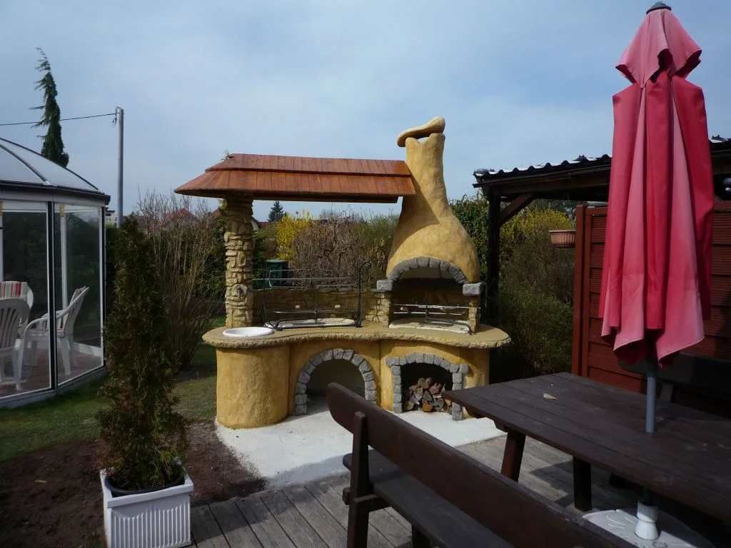 Gemauerter Grillkamin mit Holzdach auf einer Terrasse
