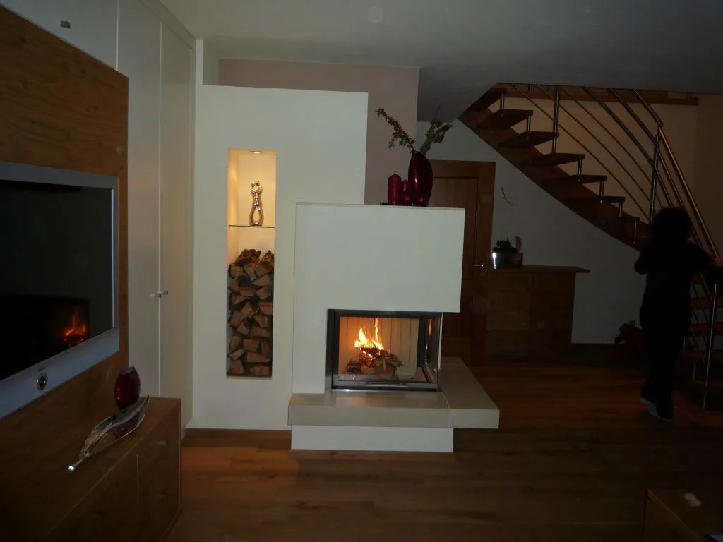 Moderner Ofen mit Sichtfeuer vor einer Holzwand